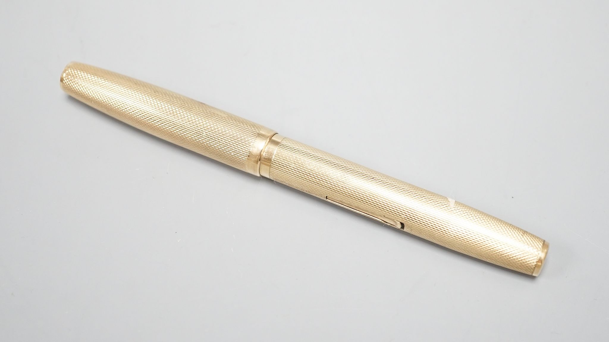 A 1940's Waterman's engine turned 9ct gold cased fountain pen, 12.9cm